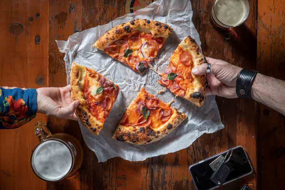 Pizza DeliDay sendo compartilhada à mesa